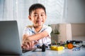 Asian kid boy learns coding and programming with laptop for Arduino robot car Royalty Free Stock Photo