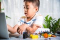 Asian kid boy learns coding and programming with laptop for Arduino robot car Royalty Free Stock Photo