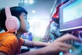 Kid is coding and scripting program on on his game streaming desktop computer with headphone on