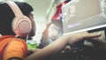 Asian kid coding and scripting program on on his game streaming desktop computer with headphone on Royalty Free Stock Photo