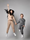 Asian kid girl and caucasian kid boy friends in stylish sportswear have fun jumping and screaming together Royalty Free Stock Photo