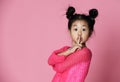 Asian kid girl in pink sweater shows shh sign Close up portrait Royalty Free Stock Photo