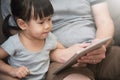 Asian kid and her father sitting and using digital tablet together. Royalty Free Stock Photo