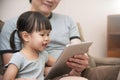 Asian kid and her father sitting and using digital tablet together. Royalty Free Stock Photo