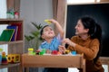 Asian kid and his teacher play doh togather in class room in preschool Royalty Free Stock Photo