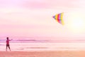 Asian kid play with flying kite at the beach at sunset time