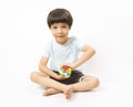 Asian kid play magic rubik cube on white background. Royalty Free Stock Photo