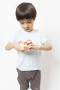 Asian kid play magic rubik cube on white background. Royalty Free Stock Photo