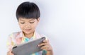 Asian kid is playing education game on tablet on white