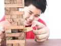 Asian kid is playing a wood blocks tower game