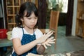 Asian kid shaping pottery