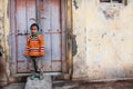 Asian kid standing in front of wooden doors