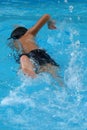 Asian kid swiming in swimming pool - front crawl style with power kick Royalty Free Stock Photo
