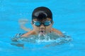 Asian kid swims in swimming pool - butterfly style take deep breath Royalty Free Stock Photo