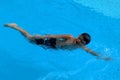 Asian kid swims in swimming pool - front crawl style