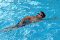 Asian kid swims in swimming pool - front crawl style take deep breath Royalty Free Stock Photo
