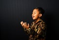 An Asian kid wearing Batik is screaming isolated on black background Royalty Free Stock Photo