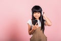 Asian kid 10 years enjoying listening music from mobile phone wear wireless headset Royalty Free Stock Photo