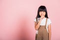 Asian kid 10 years old holding finger on lips symbol of hush gesture of asking quiet Royalty Free Stock Photo