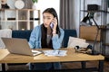 Asian Korean pretty woman talking on mobile and working on laptop at home Royalty Free Stock Photo
