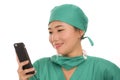 Asian Korean woman as successful physician using hand phone - young beautiful and happy medicine doctor or chief hospital nurse Royalty Free Stock Photo