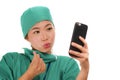 Asian Korean woman as successful taking selfie on hand phone - young beautiful and happy medicine doctor or hospital nurse taking Royalty Free Stock Photo