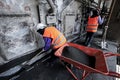 Asian labor with shovel cleanout sewage in the sewer