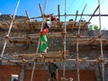 Asian labours making wooden bamboo pole structure during wall construction on site in India January 2020 Royalty Free Stock Photo