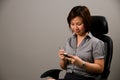 Asian lady in business attire, using a PDA Royalty Free Stock Photo