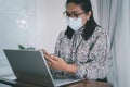 Asian lady businesswoman wearing mask for protect coronavirus to work from home communicate by conference video call on laptop, Royalty Free Stock Photo