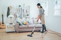 Young housewife using vacuum cleaner cleaning Royalty Free Stock Photo