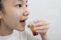 Asian lady girl rinsing the mouth or gargling with medicine of medical disinfectant,protect against the Coronavirus COVID-19 in
