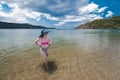 An asian lady in a high waist bikini admires the scenery at the beach. Adventure and weekend getaway theme Royalty Free Stock Photo