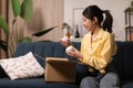 Asian Lady Holding Delivered Moisturizer Jars Unpacking Box At Home Royalty Free Stock Photo