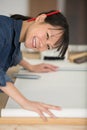 asian lady leaning over wallpapering table Royalty Free Stock Photo