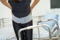 Asian lady patient wearing back pain support belt for orthopedic lumbar with walker