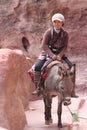 Asian lady riding donkey in Petra Jordan Royalty Free Stock Photo