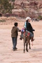 Asian lady riding donkey in Petra Jordan Royalty Free Stock Photo