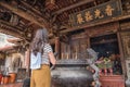 Asian lady standing in front of the censer.