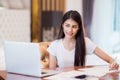 Asian lady student do home work on the desk with computer notebook