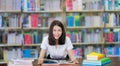 Asian lady student read a book in campus library in Universit