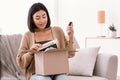 Asian lady unpacking her parcel with beauty box Royalty Free Stock Photo