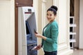 Asian lady using an automated teller machine Royalty Free Stock Photo