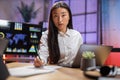 Asian lady using laptop and taking notes at office Royalty Free Stock Photo