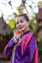 Asian lady wear a traditional costume standing in the classic thai house.The beautiful girl in folk costume is happily at the Thai