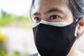 Asian lady woman wearing cloth mask on a surgical mask,people puts double or two masks on her face for COVID-19 protection,