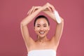 Asian lady wrapped in towel touching her skin with feather Royalty Free Stock Photo