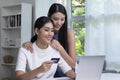 Asian lesbian couple holding credit card and using laptop computer. LGBT lesbian businesswoman working at home. Online shopping Royalty Free Stock Photo