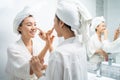 Asian lesbian gay couple putting smooth and skin care for facial soft. Attractive funny woman friend touches on face and apply Royalty Free Stock Photo