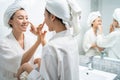 Asian lesbian gay couple putting smooth and skin care for facial soft. Attractive funny woman friend touches on face and apply Royalty Free Stock Photo